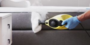 Person Steam Cleaning a Mattress