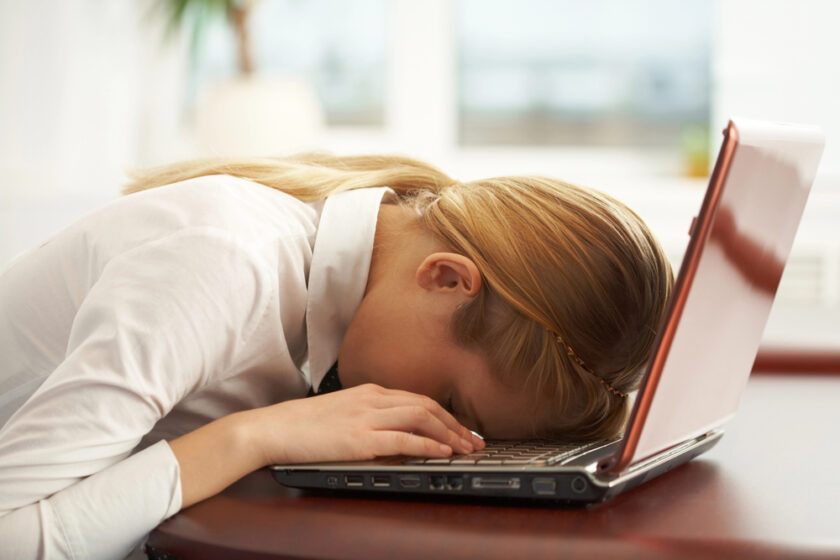 woman stressed at work with her hand on the deak