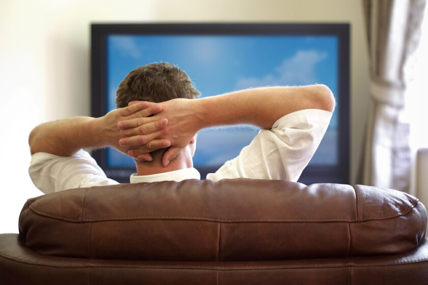 Man sat relaxing and watching the TV