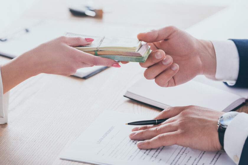 Person handing over money after taking out a loan