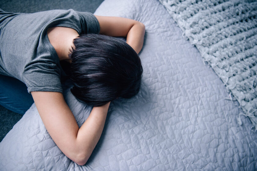 woman with her head down on a bed