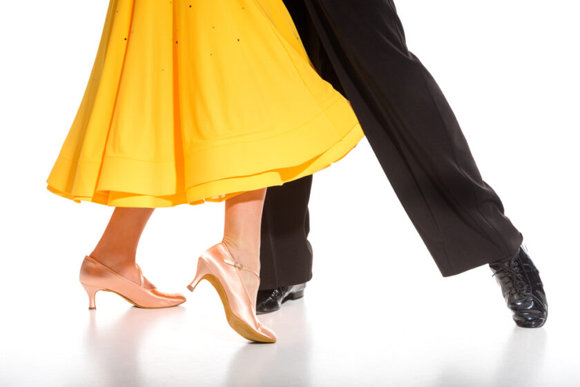 Cropped view of elegant young couple of ballroom dancers dancing on white