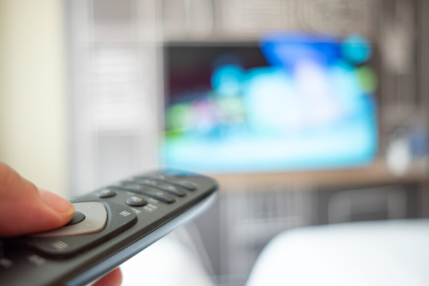 man operating a TV remote control in a hotel room