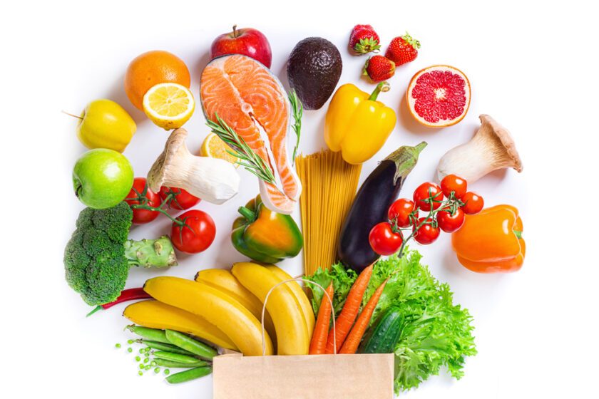 Healthy food background. Healthy food in paper bag fish, vegetables and fruits on white. Shopping food supermarket concept