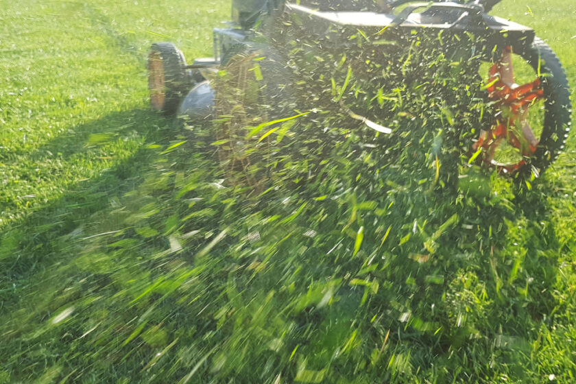 grass flying out the back of a lawn mower