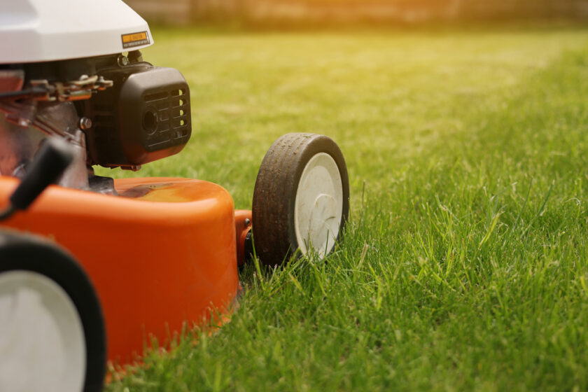 Gardening work tools. Close up details of orange electric lawn mower