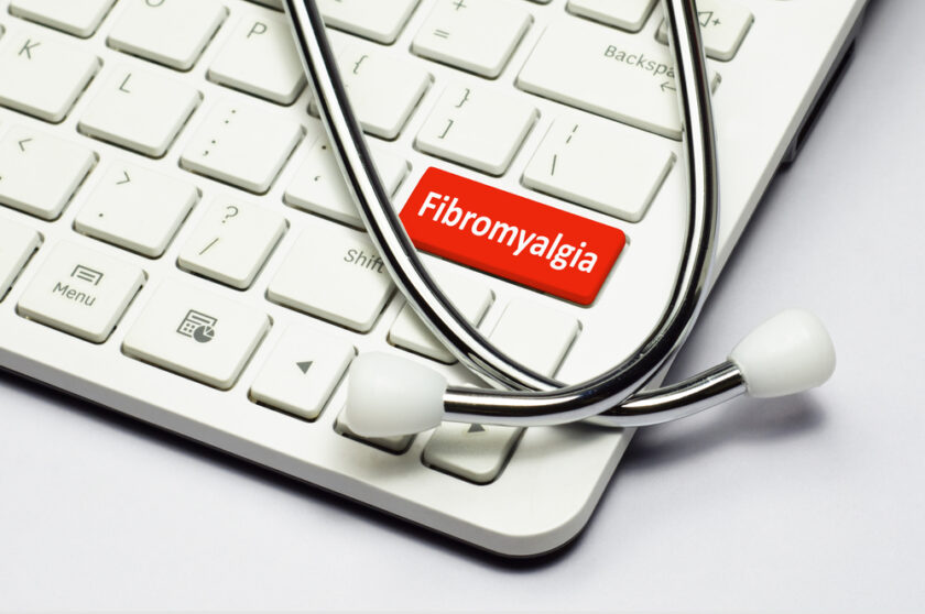 Fibromyalgia text, stethoscope lying down on the cumputer keyboard