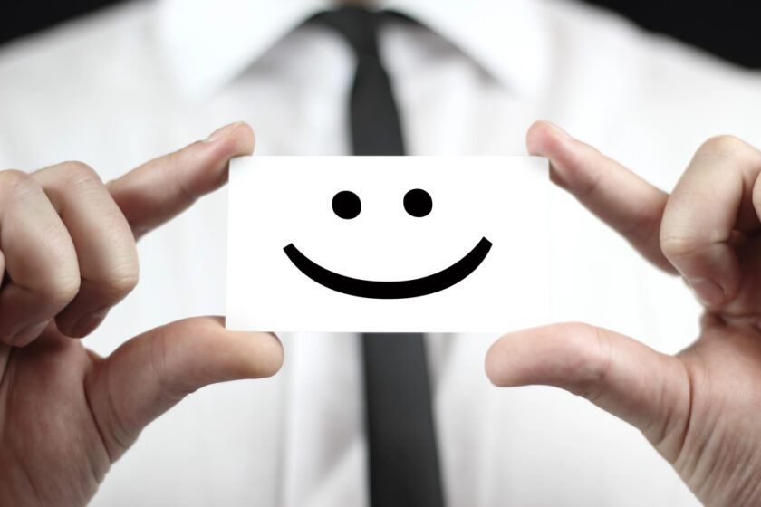 Busness person holding a smiling face