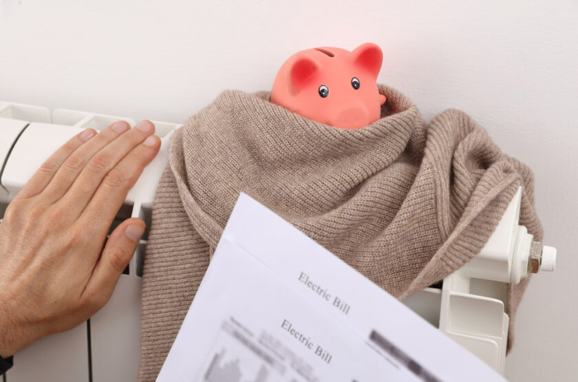 Piggy bank wrapped in a blanket on a radiator