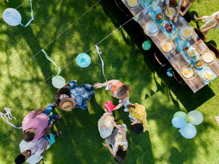 Top view of a garden party with decorations and a set table.