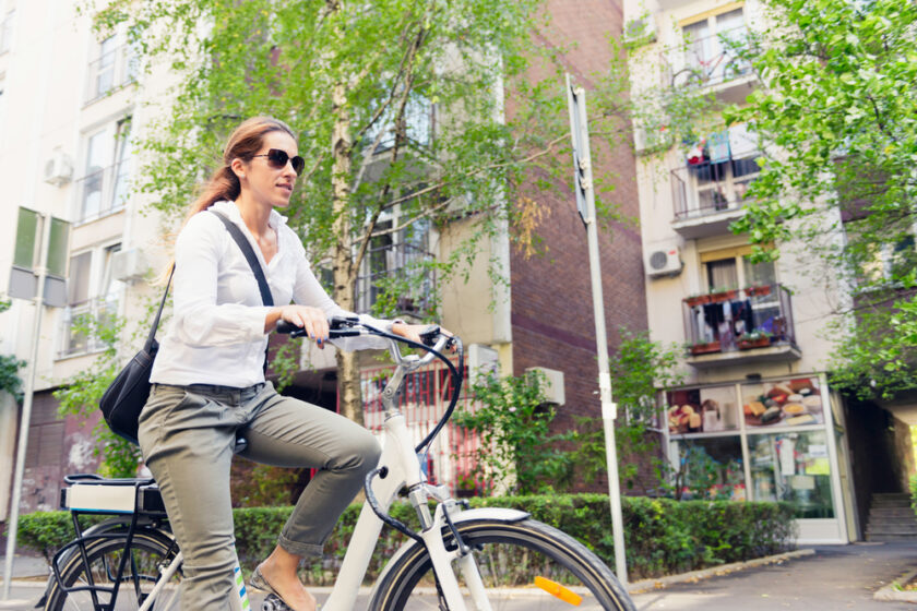 E-bike commuter, riding through a city block
