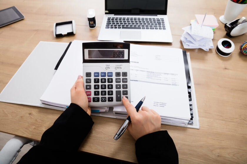 Someone working on expenses on a calculator