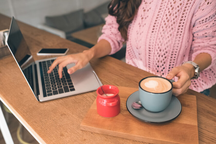 person working from home on their laptop with a cup of coffee