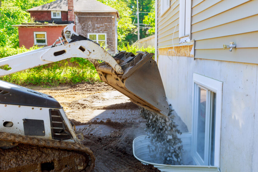 Moving gravel scoop building materials window well for basement construction new residential home