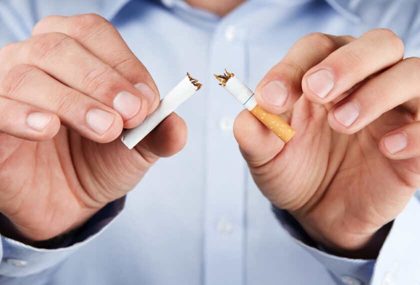 Person breaking a cigarette in half