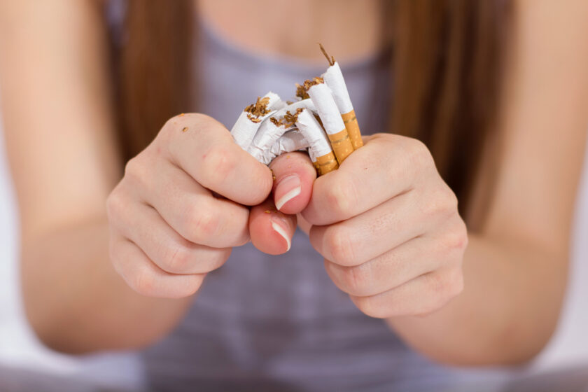 Quit Smoking, woman hands breaking bunch of cigarette.