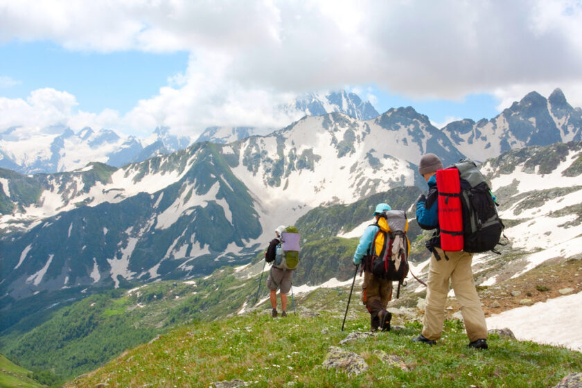 Two people backpacking with a mountain range behind them