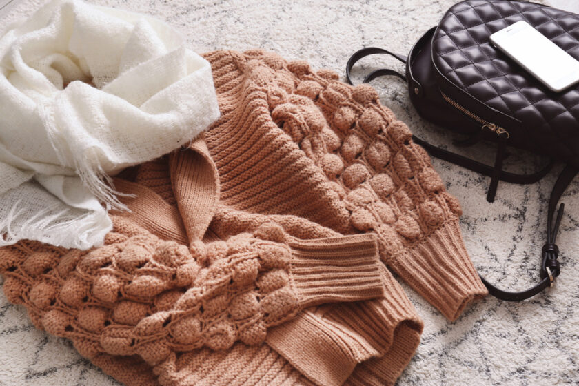 winter clothing laying out on a bed