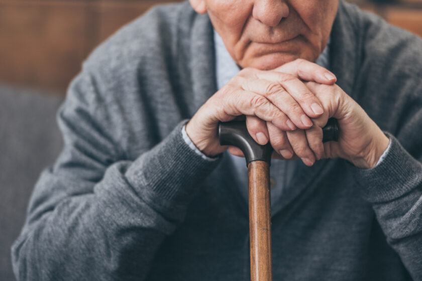 older man leaning on a walking stick