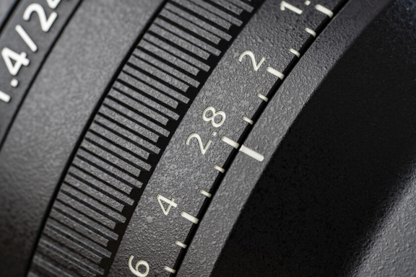 An new camera lens, close up. The lens, focus and exposure controls of a mirrorless camera, macro