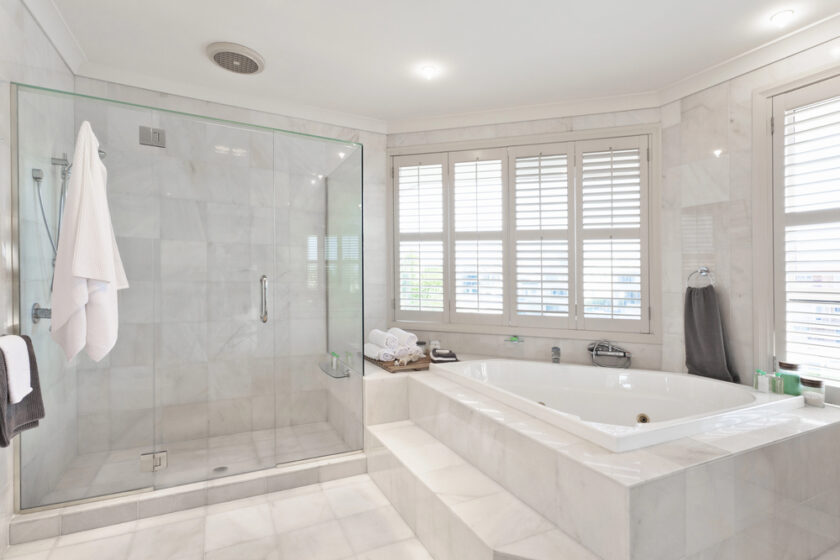 A stylish bathroom featuring a spacious glass shower and luxurious spa bath.