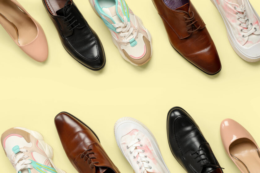 Various types of shoes, including brown and black dress shoes, pink heels, and colorful sneakers, are arranged in lines on a light yellow background.