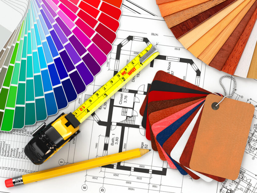 Color swatches, architectural blueprints, a yellow pencil, a tape measure, and material samples are arranged together, suggesting the planning and design process for construction or interior decoration.