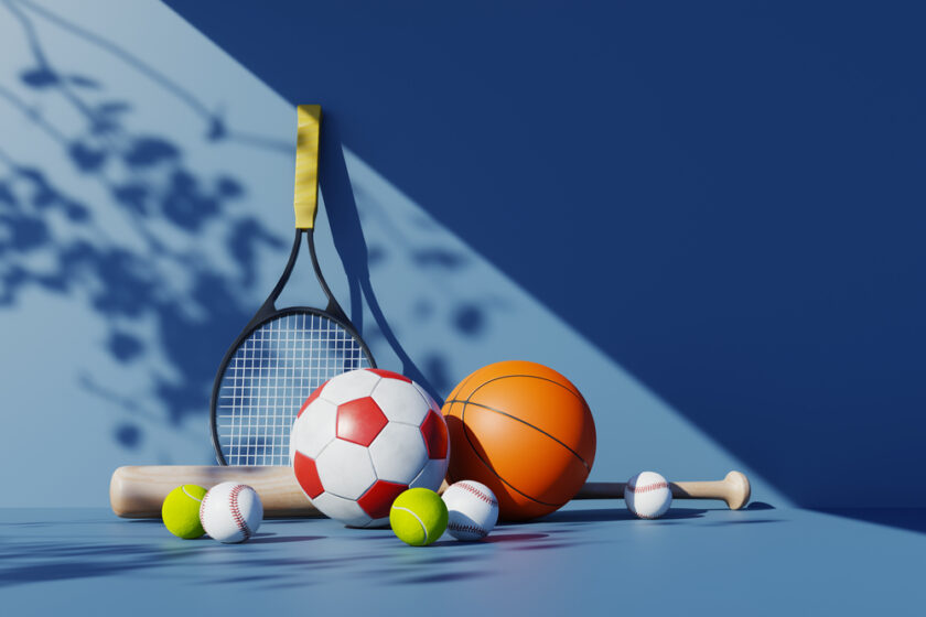 A group of sports equipment including a tennis racket, soccer ball, basketball, baseball bat, and several baseballs and tennis balls on a blue surface with a shaded background.