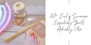 A reed diffuser, wooden sticks, and a Yankee Candle box sit on a white wooden surface beside pastel neon lights. Text reads: 20+ End of Summer Essentials You'll Actually Use.