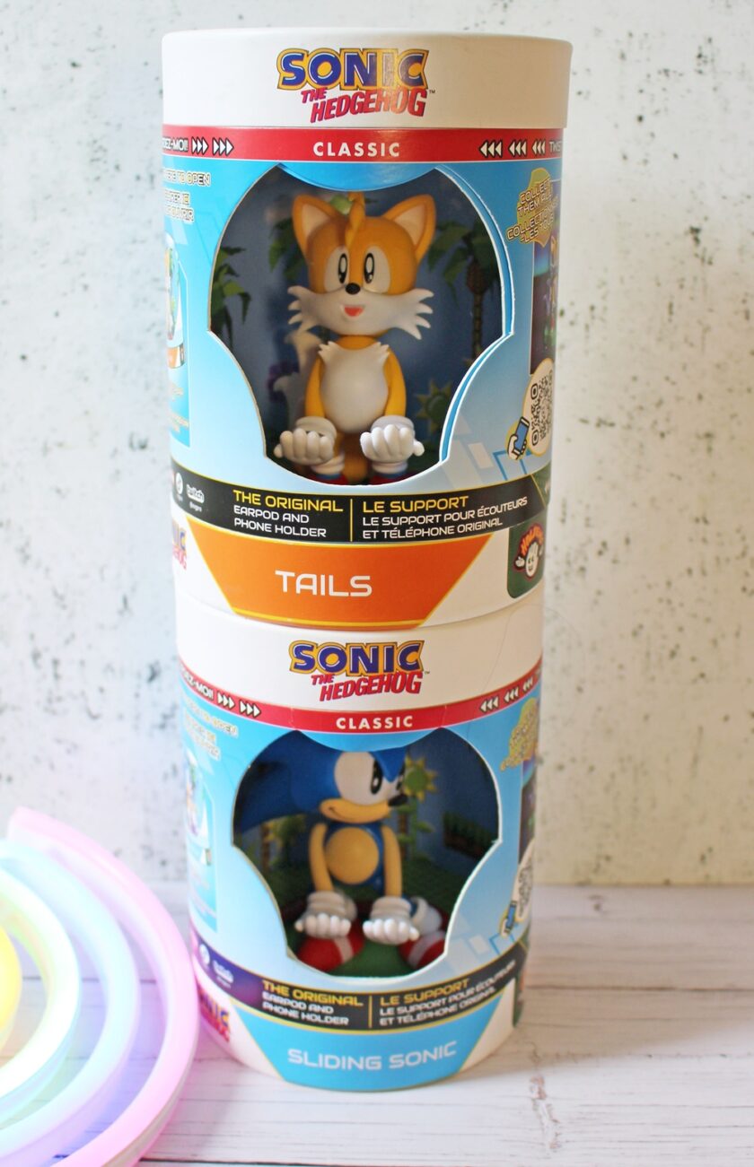 Two Sonic the Hedgehog Classic collectable figure boxes are stacked. The top box features Tails and the bottom features Sonic. Both are labelled as headphone holders. A colourful light is partially visible in the corner.