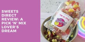A bag of colourful pick 'n' mix sweets spills into a bowl next to a neon rainbow light. Text on a purple background reads: Sweets Direct Review: A Pick 'n' Mix Lover's Dream.