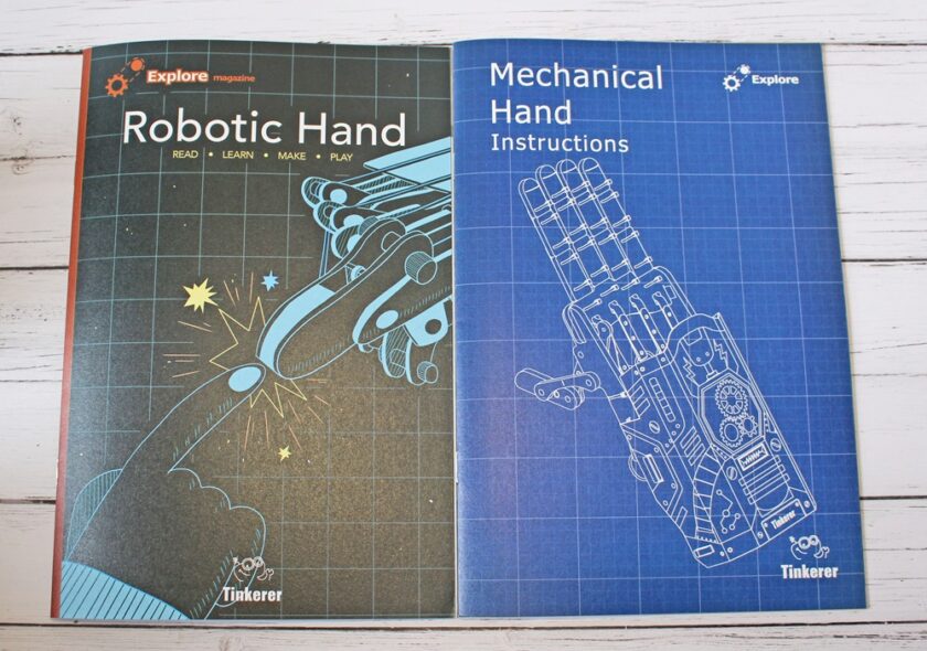 Two instruction booklets are side by side. The left one is titled Robotic Hand with an illustration of a robotic and a human hand touching. The right one is titled Mechanical Hand Instructions with a blueprint-style hand drawing.