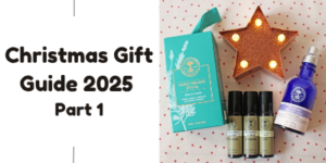 A holiday-themed flat lay with essential oils, a blue bottle, a teal gift box, and a lit star ornament beside text reading Christmas Gift Guide 2025 Part 1 on a white background.
