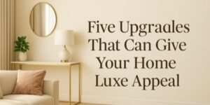 A stylish sitting room with a round mirror, lamp, and minimalist table next to a beige sofa. Text on the wall reads: “Five Upgrades That Can Give Your Home Luxe Appeal.”.