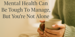 A person in a cosy jumper holds a mug, with text beside them that reads, Mental Health Can Be Tough To Manage, But You’re Not Alone.