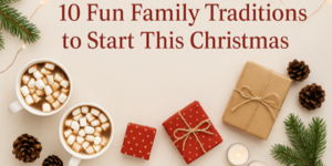 Two mugs of hot chocolate with marshmallows, wrapped presents, pine cones, fir branches, and fairy lights are arranged on a beige surface. Text reads: 10 Fun Family Traditions to Start This Christmas.