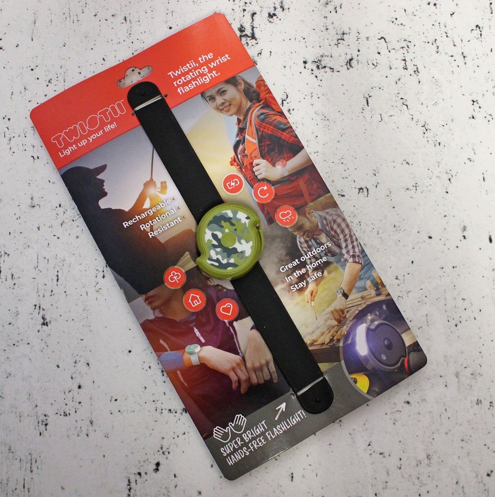 A packaged TYQOTI children’s wrist torch, similar to the Twistii Torch, with a green dinosaur design, shown on colourful cardboard backing featuring children using the torch and highlighted product features.