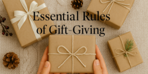 Four hands hold a neatly wrapped present with string on a table. Three more brown paper parcels, pine cones, and berries surround it. Text reads: Essential Rules of Gift-Giving.