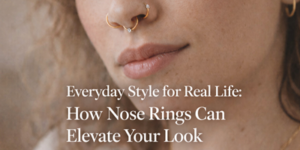 Close-up of a person with light skin wearing two gold nose rings and subtle make-up. Text overlay reads: Everyday Style for Real Life: How Nose Rings Can Elevate Your Look.