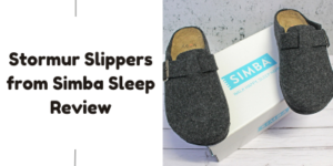 A pair of dark grey Stormur Slippers from Simba Sleep rest on a white Simba-branded box, with bold text reading Stormur Slippers Review from Simba Sleep displayed on a clean white background.