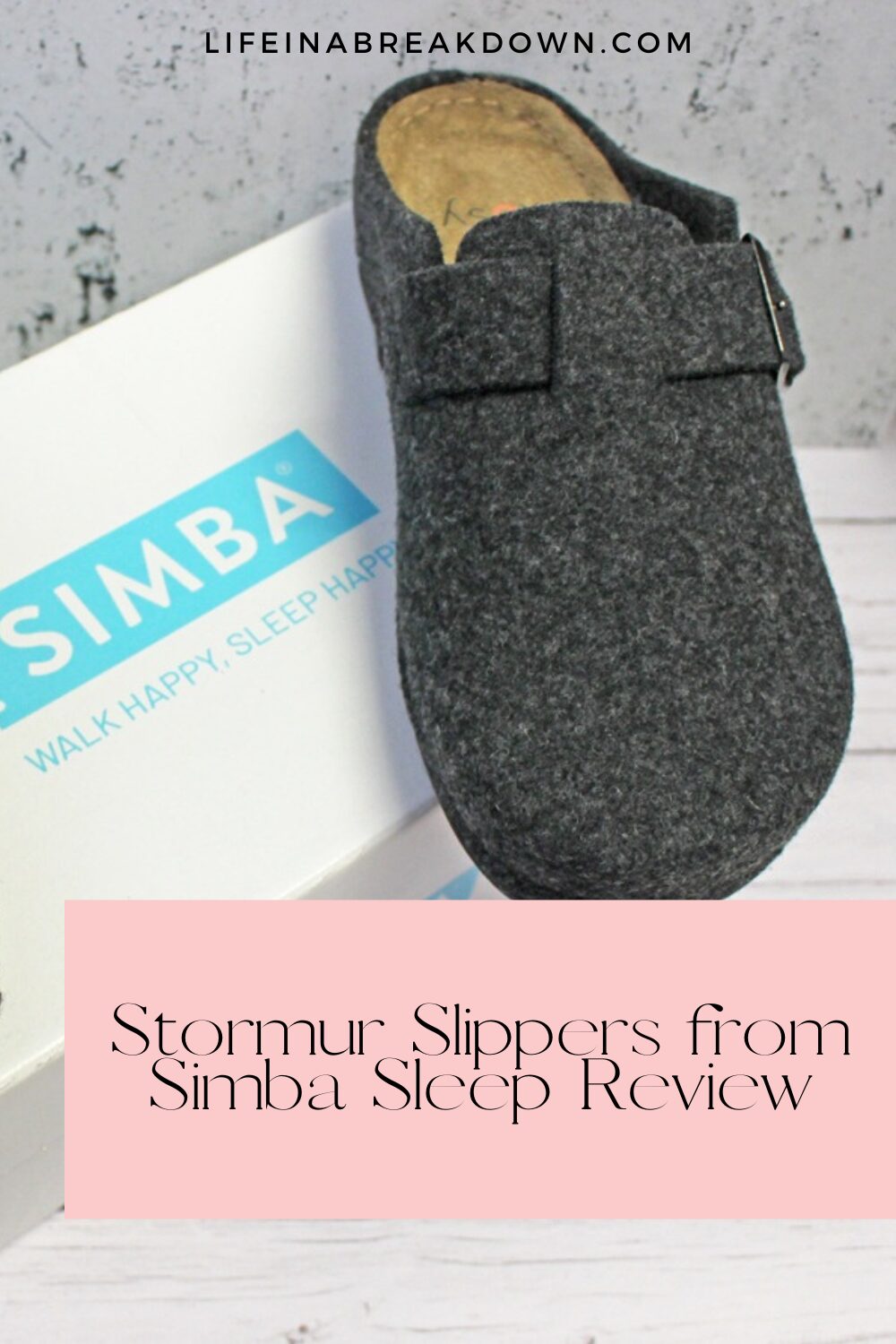 A grey felt Stormur Slipper is displayed atop a white Simba shoe box with turquoise branding. Text overlay reads, Stormur Slippers from Simba Sleep Review. The background features light wood for a cosy touch.