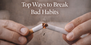 A close-up of two hands breaking a burning cigarette in half, with the text Top Ways to Break Bad Habits above.