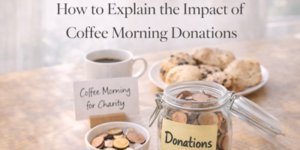 A jar labelled Donations filled with coins sits on a table next to a coffee cup, a small bowl of coins, a sign reading Coffee Morning for Charity, and a plate of scones, with text about coffee morning donations.