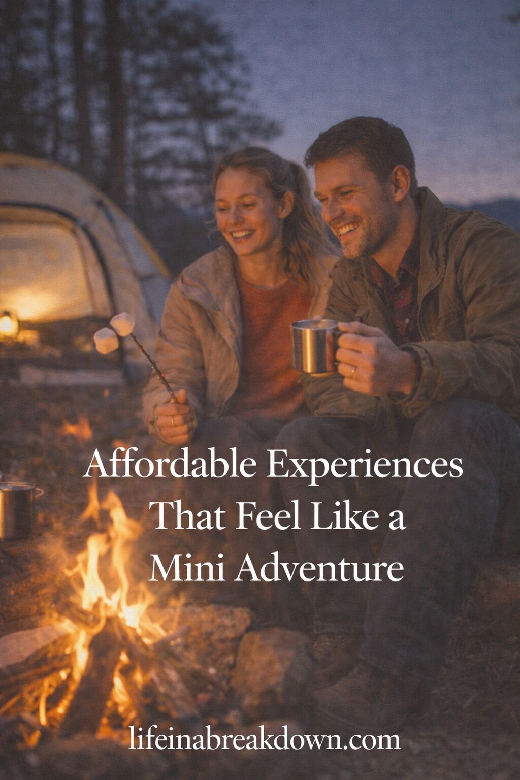 A smiling couple sits by a campfire, toasting marshmallows and holding mugs, with a lit tent and trees in the background. Text reads: Affordable Experiences That Feel Like a Mini Adventure. lifeinabreakdown.com.