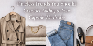 A beige trench coat, folded jumpers, blue jeans, black loafers, and a brown handbag are arranged under text that reads, Timeless Trends You Should Consider Adding to Your Capsule Wardrobe.