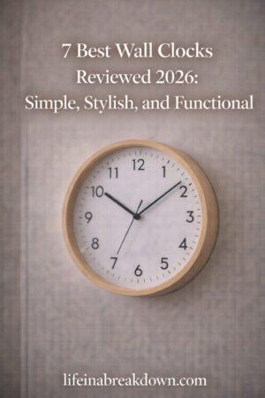 A simple round wall clock with a light wooden frame hangs on a beige textured wall. Text above reads 7 Best Wall Clocks Reviewed 2026: Simple, Stylish, and Functional. Website lifeinabreakdown.com is at the bottom.