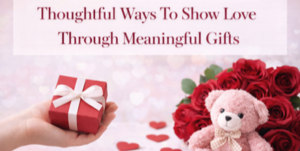 A hand holds a red gift box with a white ribbon. Nearby are a bouquet of red roses, a pink teddy bear, and scattered red heart shapes. Text above reads, Thoughtful Ways To Show Love Through Meaningful Gifts.