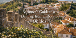 View of the hilltop town of Óbidos, Portugal with white houses and orange roofs surrounded by stone walls, and text overlay: Beginner’s Guide to a Day Trip from Lisbon to Óbidos.
