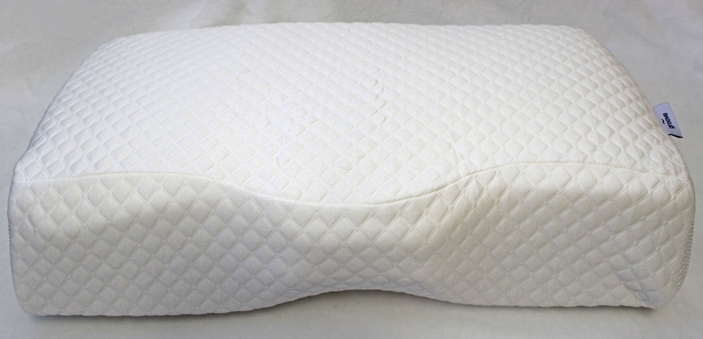 A white, ergonomic memory foam pillow with a quilted diamond pattern cover, featuring a curved design for neck support, placed on a plain surface.