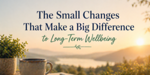 A mug and potted plant sit on a table overlooking a scenic lake and mountains at sunrise, with text reading, The Small Changes That Make a Big Difference to Long-Term Wellbeing.